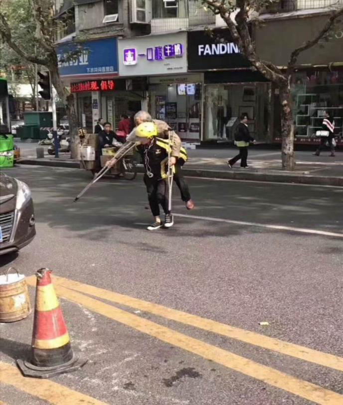 美团外卖骑手送餐不忘助人 背拄拐老人过马路