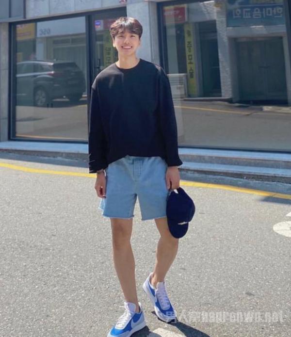 韩国男生总是走在潮流前沿,深色的长袖卫衣混搭一条浅色牛仔短裤,配