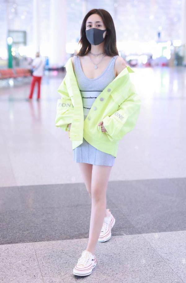 刘芸荧光绿外套搭灰色裙亮相机场 出现初秋运动女团风