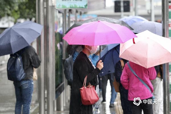 北京雨水飘落秋意浓 街头市民换厚装撑伞出行