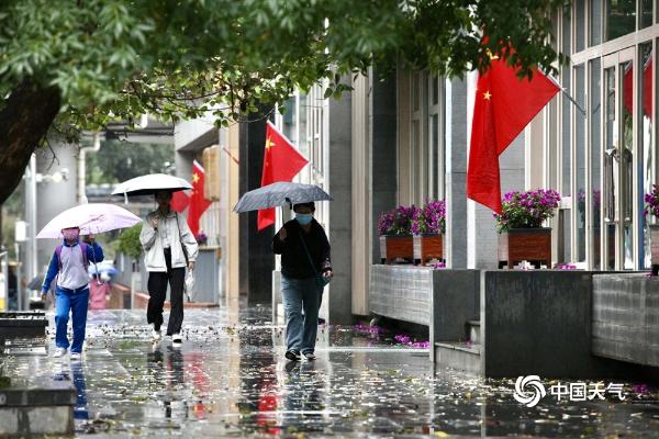 北京雨水飘落秋意浓 街头市民换厚装撑伞出行