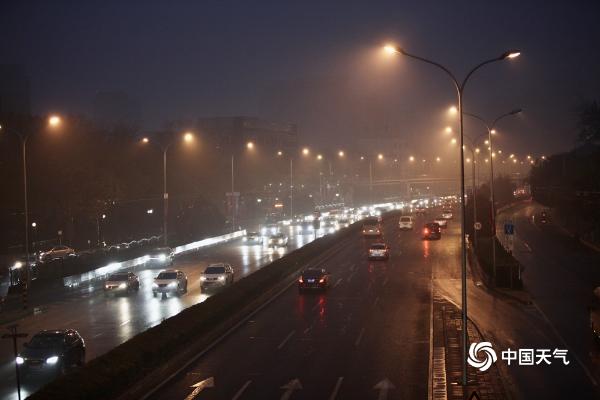 北京遭遇入冬后首场降雨 道路湿滑行人撑伞出行
