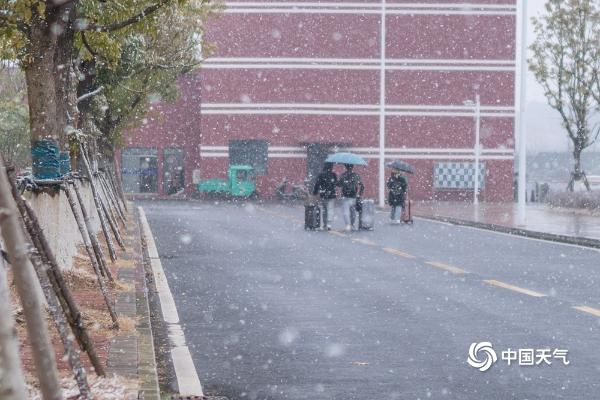 江西共青城市现明显降雪 学生顶风雪返乡