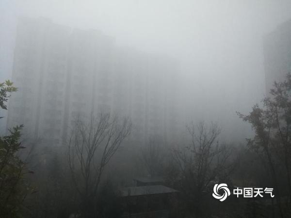 大雾和霾齐袭 北京楼宇模糊行人口罩遮面