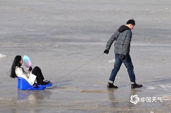 松花江哈尔滨段封冻 游人滑冰拍照流连忘返