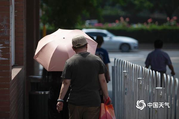 北京气温破30℃晴热暴晒 街头行人着装清凉
