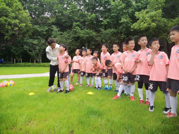 在“红房子”与小学生赛足球，王霜推介“咸伙计”为家乡代言
