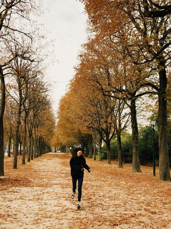 "照片中,刘雯身穿黑色宽松卫衣配黑色紧身裤,踩着落叶一路狂奔,一头黑