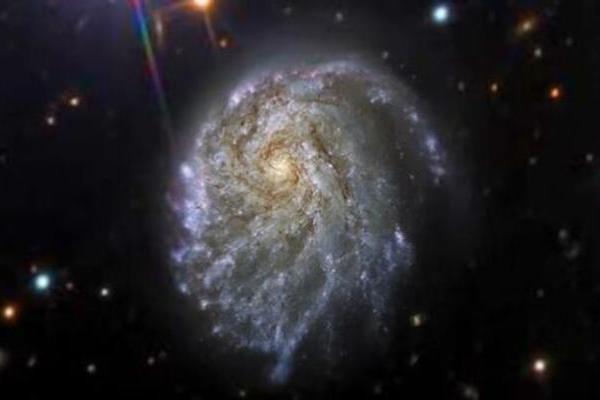 NASA哈勃太空望远镜发现一个螺旋星系：形状扭曲却惊艳，距地球1.2亿光年 